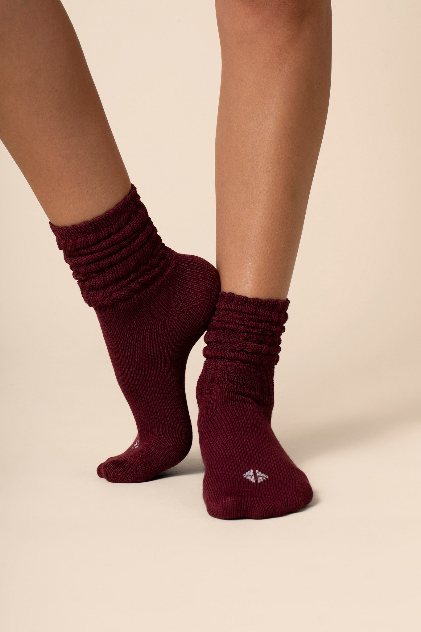 Maroon socks worn by a person on a beige background