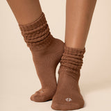 Brown scrunch socks worn by a person on a beige background