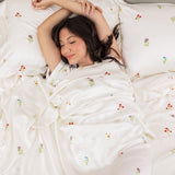Female laying in bed on the Bamboo Sateen Sheet Set in Wildflower