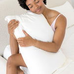 Female holding a pillow with the Bamboo Sateen Pillowcase in Shell on it