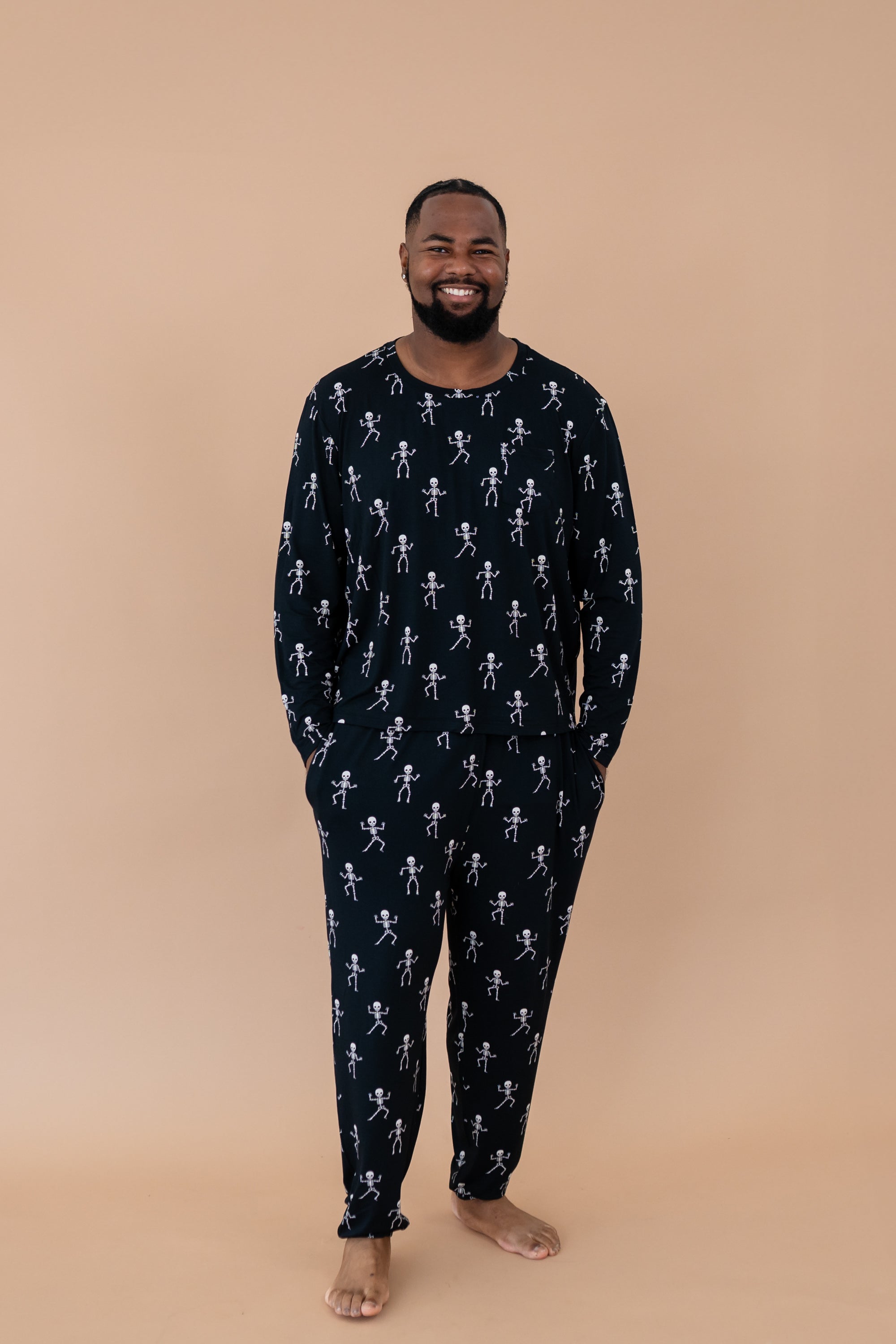Smiling man with hands in pockets modeling the Men's Jogger Set in Skeleton 