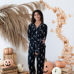 Smiling model in front of a Fall backdrop wearing the Long Sleeve Pajama Set in Skeleton 