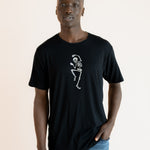 Modal wearing Black Men's Crew Neck Tee with Skeleton print in center over blue jeans on a beige background ::: Model is 6'1" wearing size L ///