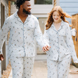 Smiling couple walking down a sidewalk wearing matching Men's and Long-Sleeved Women's Pajama Set in Ski