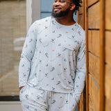 Smiling male model wearing the Men's Jogger Set in Ski looking off to the side leaning up against a fence 