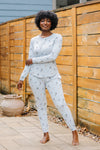 Smiling model wearing the Women's Jogger Pajama Set in Ski standing beside a wooden fence ::: Model is 5'6" wearing size M ///