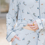 Female wearing the Long-Sleeved Women's Pajama Set in Ski holding the hem of the shirt up showing the waist of the pants 
