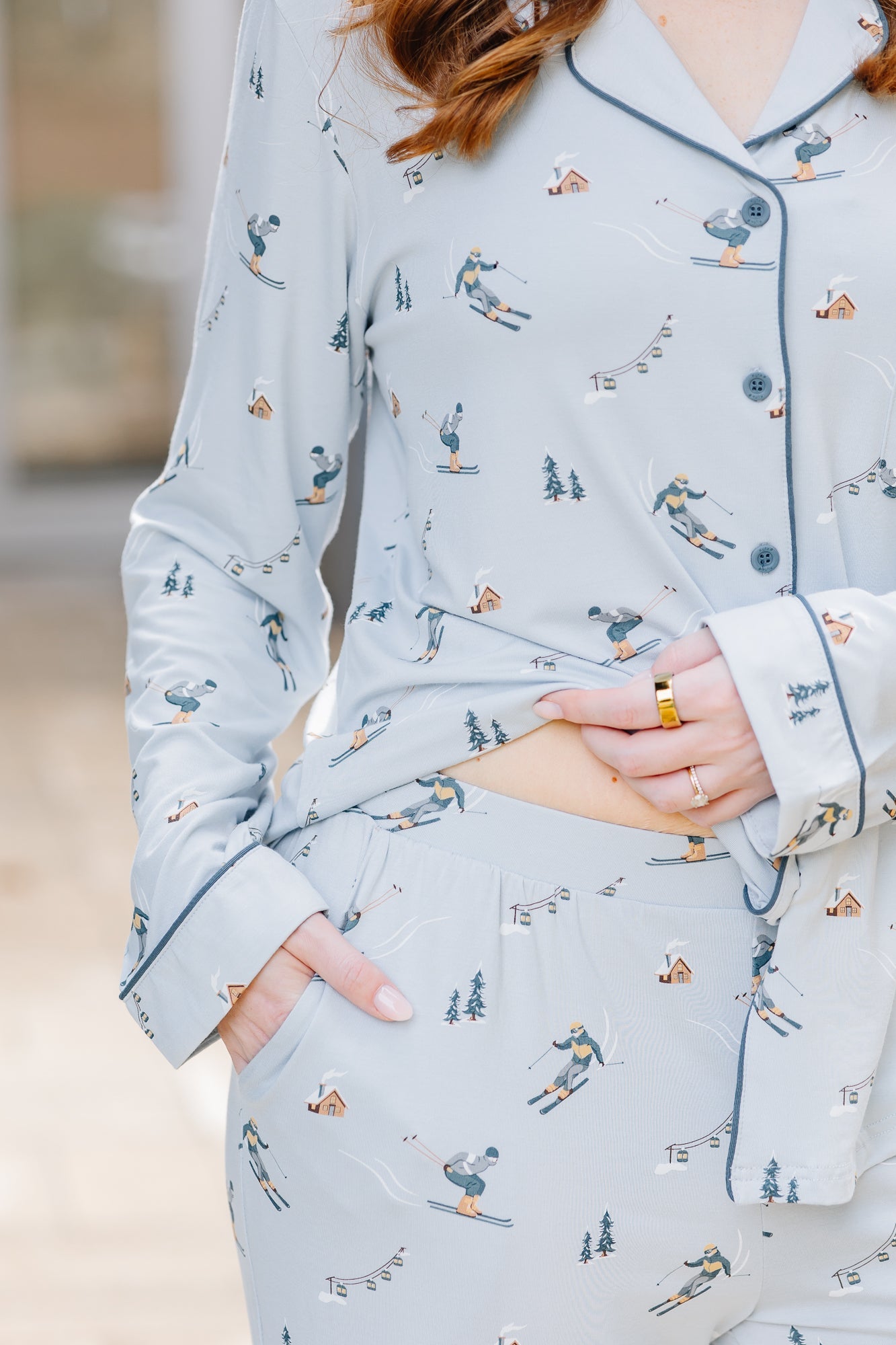 Female wearing the Long-Sleeved Women's Pajama Set in Ski holding the hem of the shirt up showing the waist of the pants 