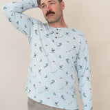 Male modeling the Men's Long Sleeve Henley Top in Ski looking off to the side with one hand up behind his head