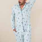 Male modeling the Men's Long Sleeve Pajama Set in Ski with one hand in the pants pocket and the other up behind is head