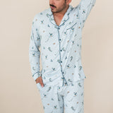 Male modeling the Men's Long Sleeve Pajama Set in Ski with one hand in the pants pocket and the other up behind is head