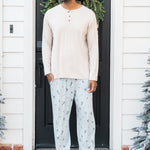 Male model standing in front of a doorway wearing the Men's Lounge Pants in Ski paired with a cream shirt
