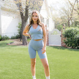 Female modeling the Bamboo Flex High Rise Biker Short in Slate paired with a matching bra tank 

::: Model is 5'4" wearing size S ///