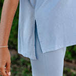 Person wearing light blue shorts with a blurred green background