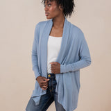 Woman model wearing the Women's French Terry Wrap Top in Slate with a white top and dark wash ripped jeans