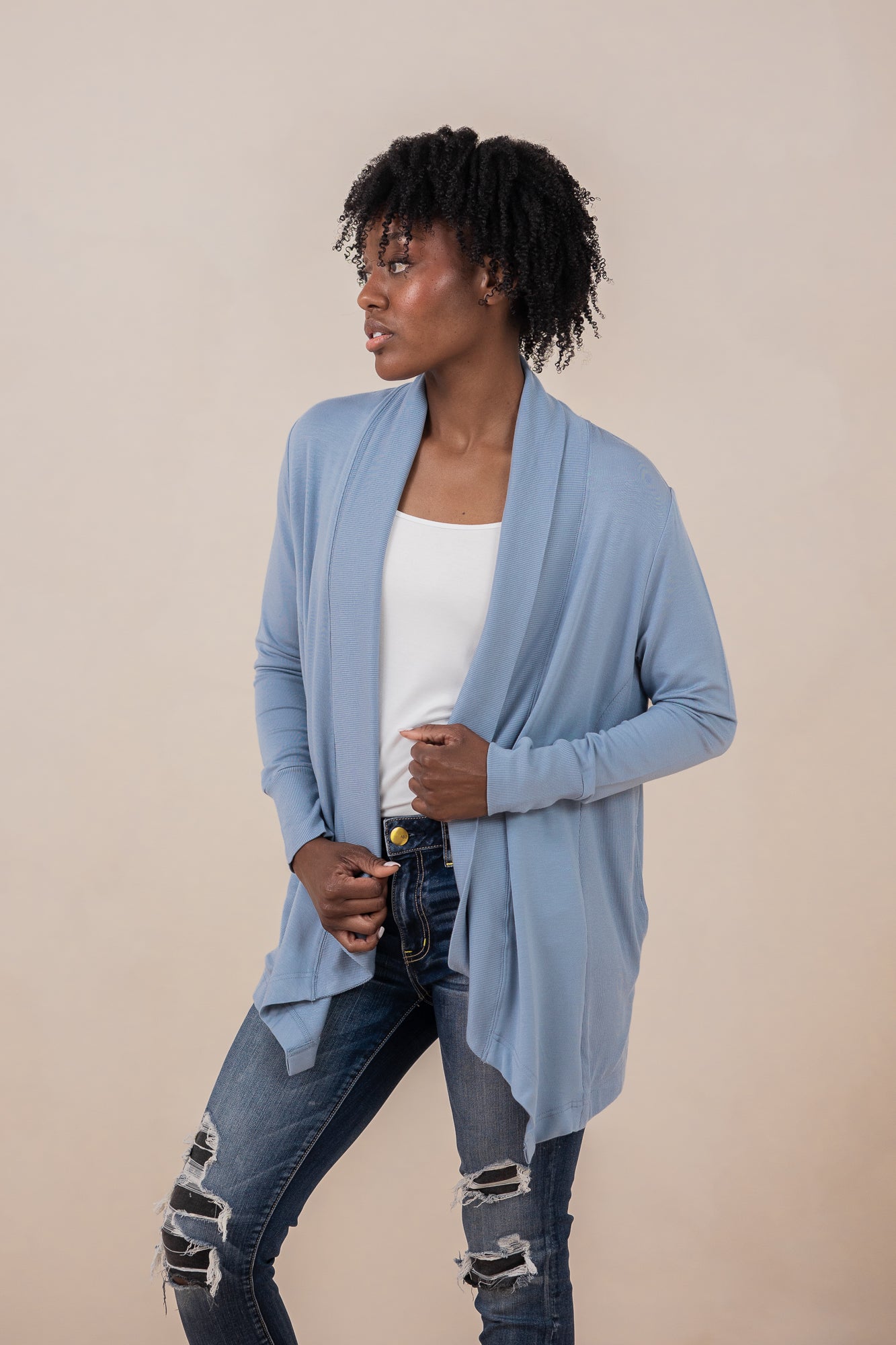 Woman model wearing the Women's French Terry Wrap Top in Slate with a white top and dark wash ripped jeans