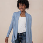 Female model wearing the Women's French Terry Wrap Top in Slate with a white top and dark wash jeans