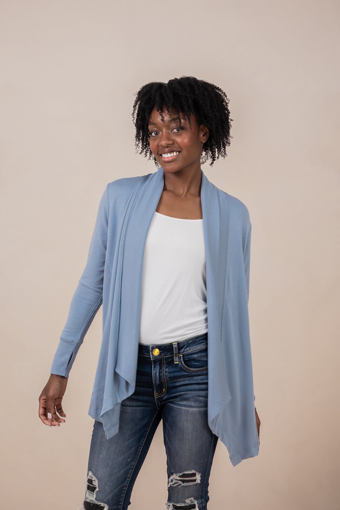 Female model wearing the Women's French Terry Wrap Top in Slate with a white top and dark wash jeans