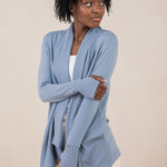 Model with arm crossed across her stomach while wearing the Terry Wrap Top in Slate with light pants