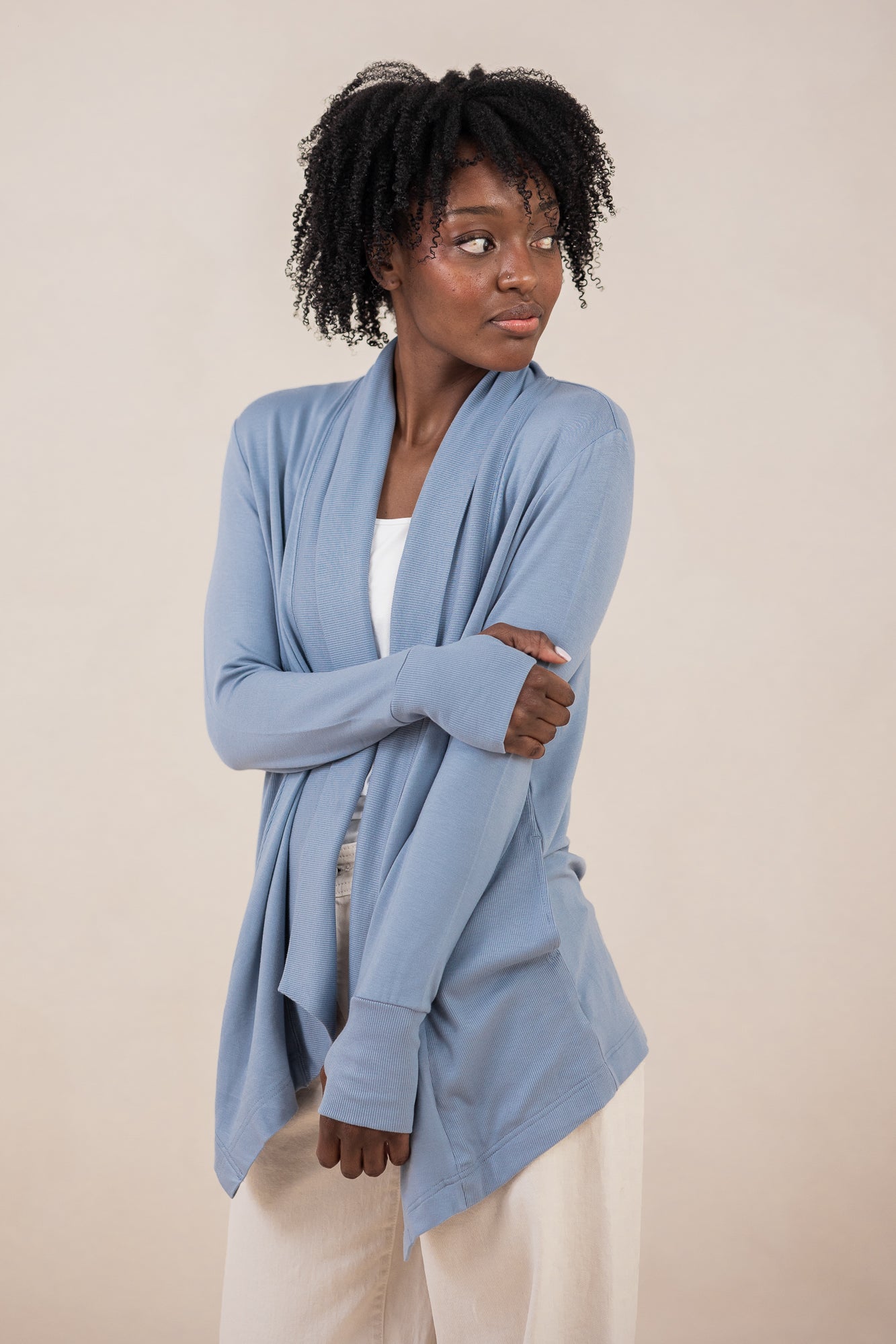 Model with arm crossed across her stomach while wearing the Terry Wrap Top in Slate with light pants
