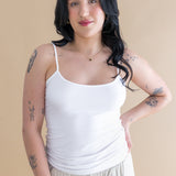 Woman wearing a white tank top and beige pants against a beige background ::: Model is 5'6" wearing size M ///
