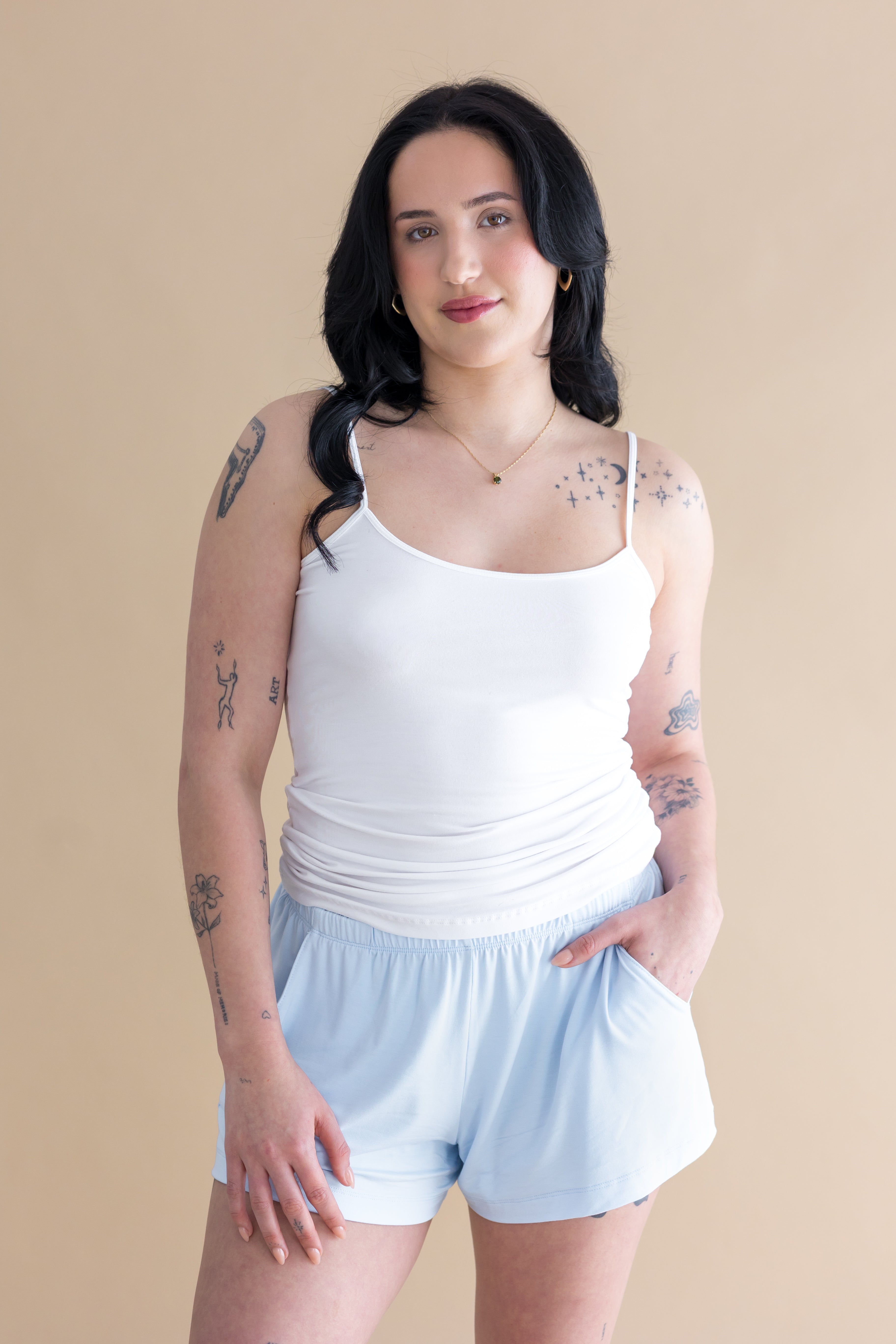 Woman wearing white tank and blue lounge shorts 