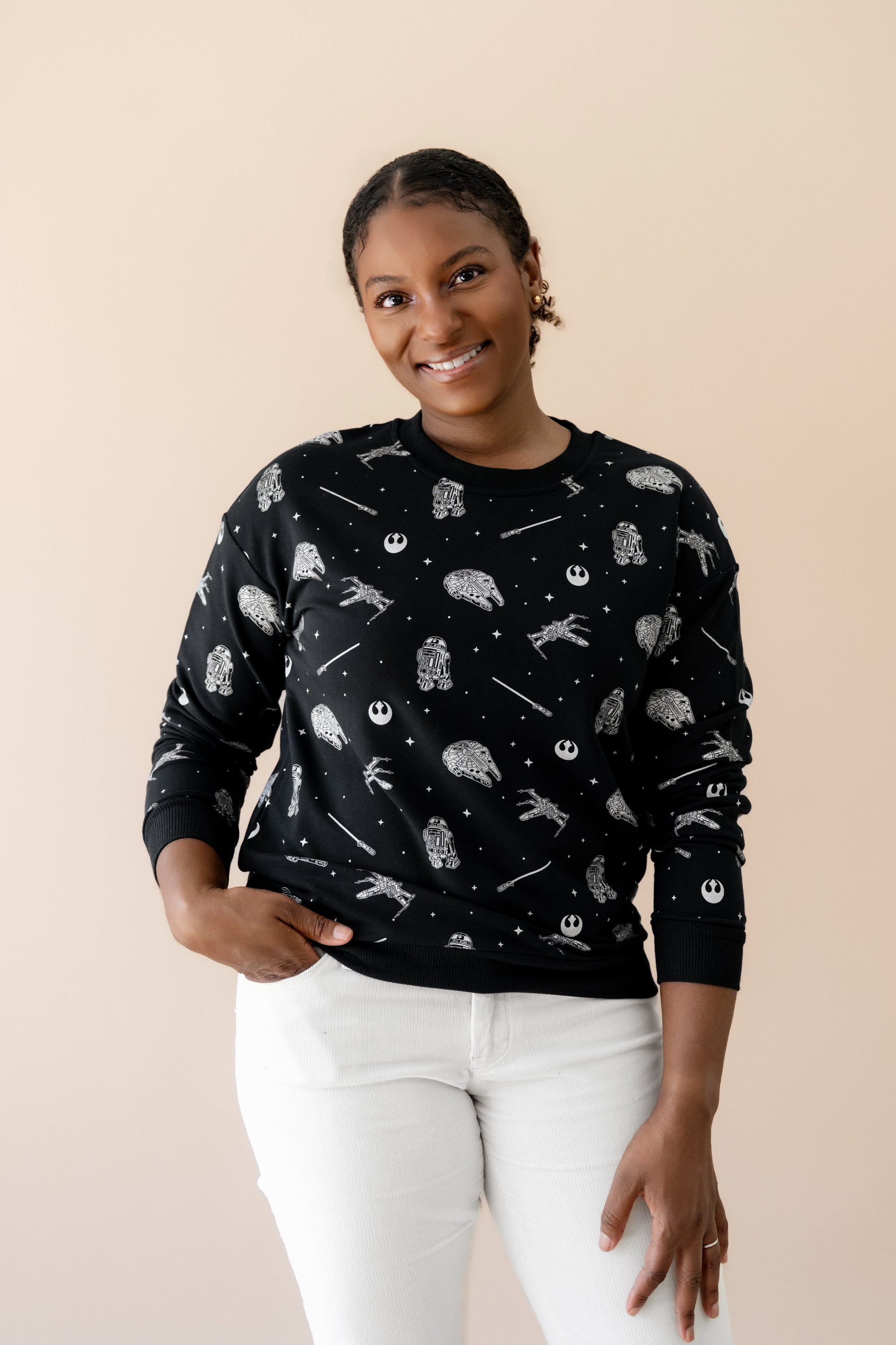 Smiling female wearing the Women's Sweatshirt in STAR WARS™ with cream colored pants

::: Model is 5'1" wearing size S ///