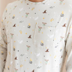Person wearing a men's jogger set pocket shirt having Harry Potter prints on a cream fabric