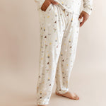 Person wearing men's jogger set pajama with pocket having Harry Potter prints on cream fabric