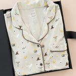 Long-Sleeved Women's Pajama Set in Starry Icon print packed in a box on a beige background