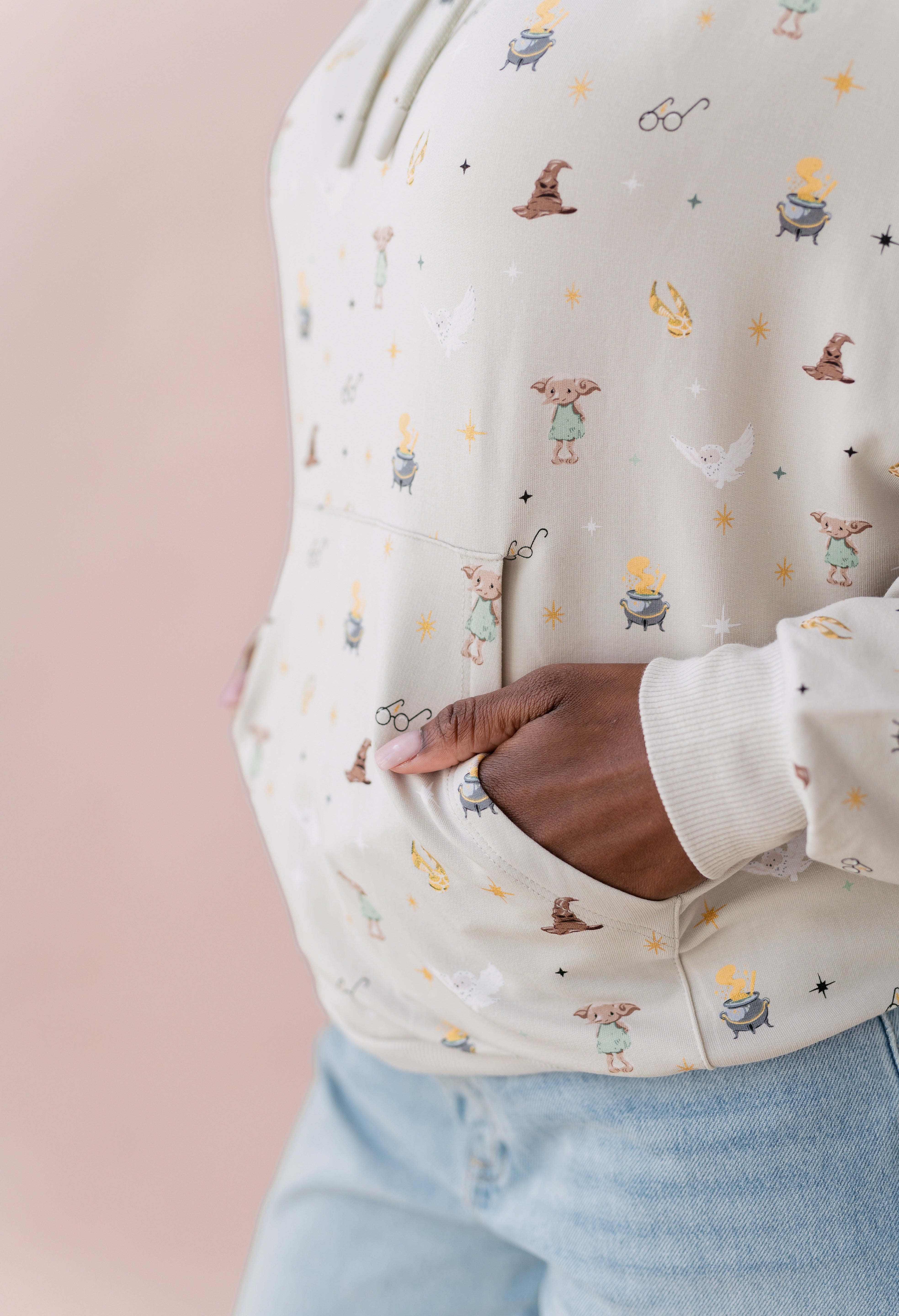 Close up on pocket detail of a beige hoodie with Harry Potter icons printed 