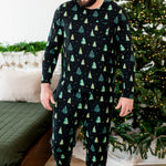 Made model looking downwards while wearing the Men's Jogger Set in Twinkle Trees next to a Christmas tree