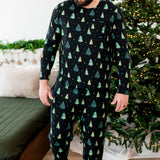 Made model looking downwards while wearing the Men's Jogger Set in Twinkle Trees next to a Christmas tree