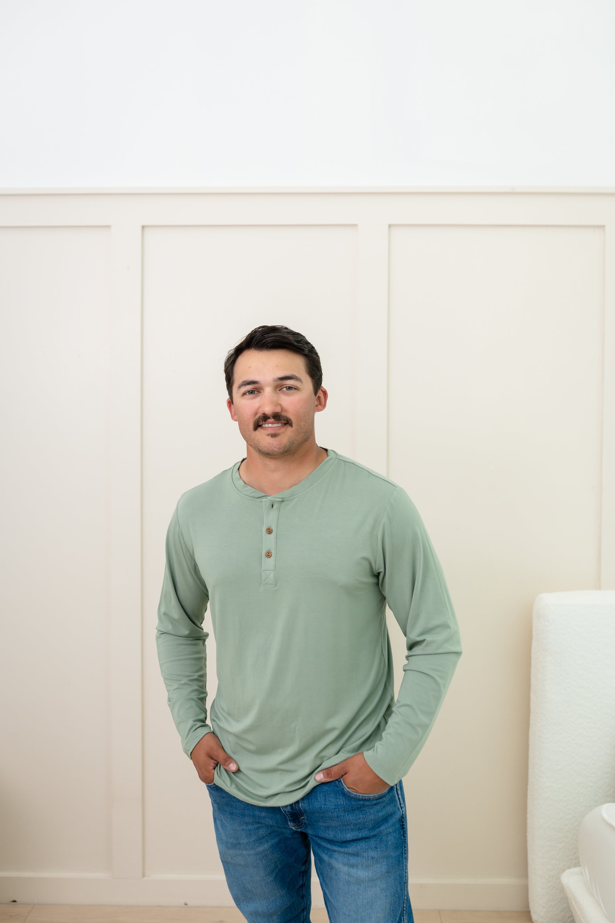 Man modeling Men's Long Sleeve Henley Top in Thyme with jeans