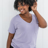 Woman with hand in hair while modeling the Women's V Neck in Taro paired with dark jeans