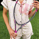 Close up of the Women's Short Sleeve Pajama Set in Tennis while model holds a a tennis racket in the front of her body