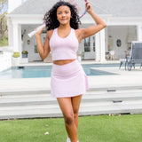 Female model standing in front of the pool posing with a tennis racket above her head wearing the Bamboo Flex Bra Tank in Thistle and matching skort

::: Model is 5'0" wearing size XS ///