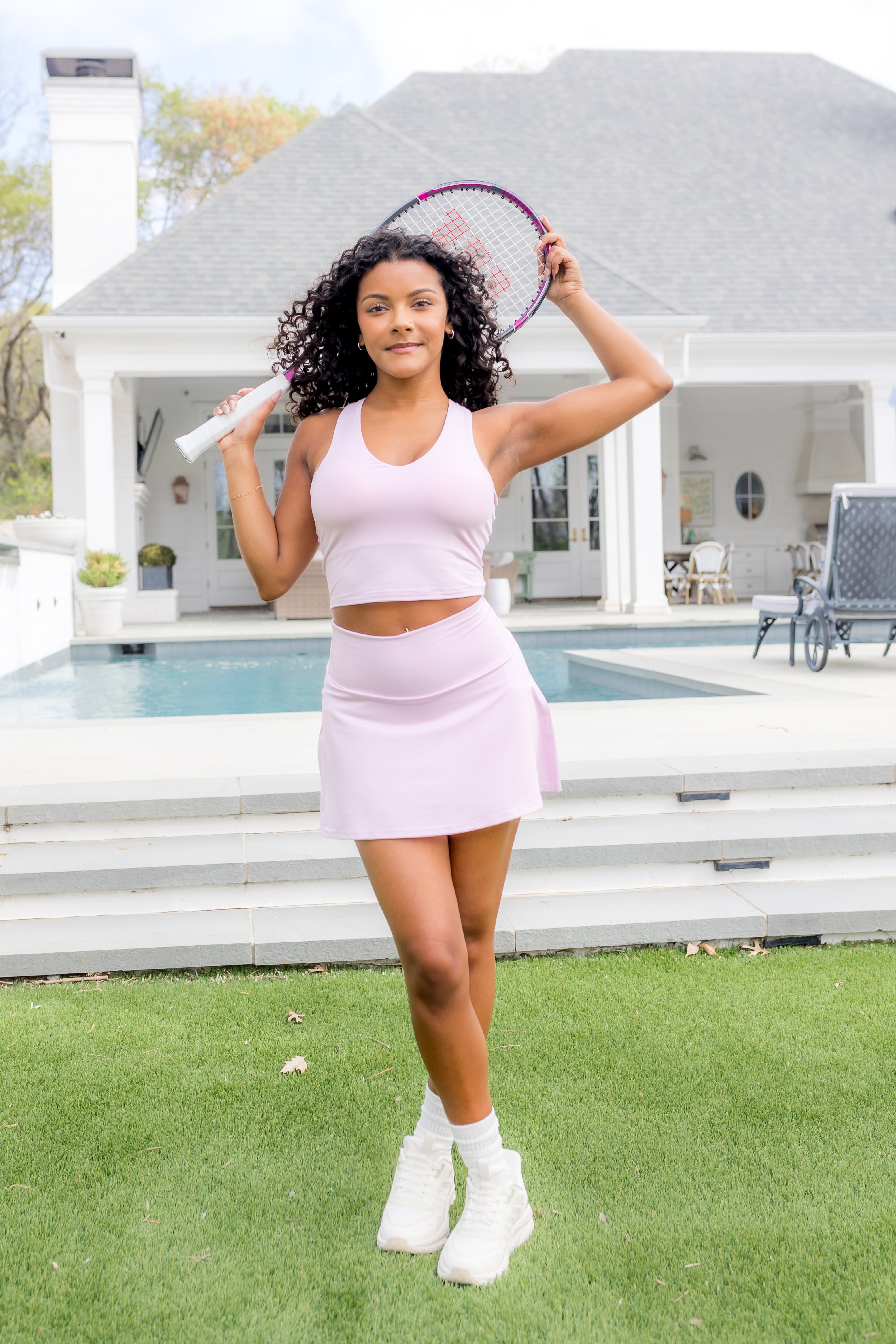 Female model standing in front of the pool posing with a tennis racket above her head wearing the Bamboo Flex Bra Tank in Thistle and matching skort

::: Model is 5'0" wearing size XS ///