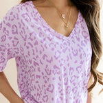 Women's Relaxed Fit V-Neck in Thistle Leopard print over a white pant on a beige background ::: Model is 5'3" wearing size S ///