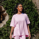 Model looking to the side while standing in front of a wall of greenery while wearing the Kyte Bamboo Women’s Biker Short Set in Thistle
::: Model is 5'9" wearing size M ///