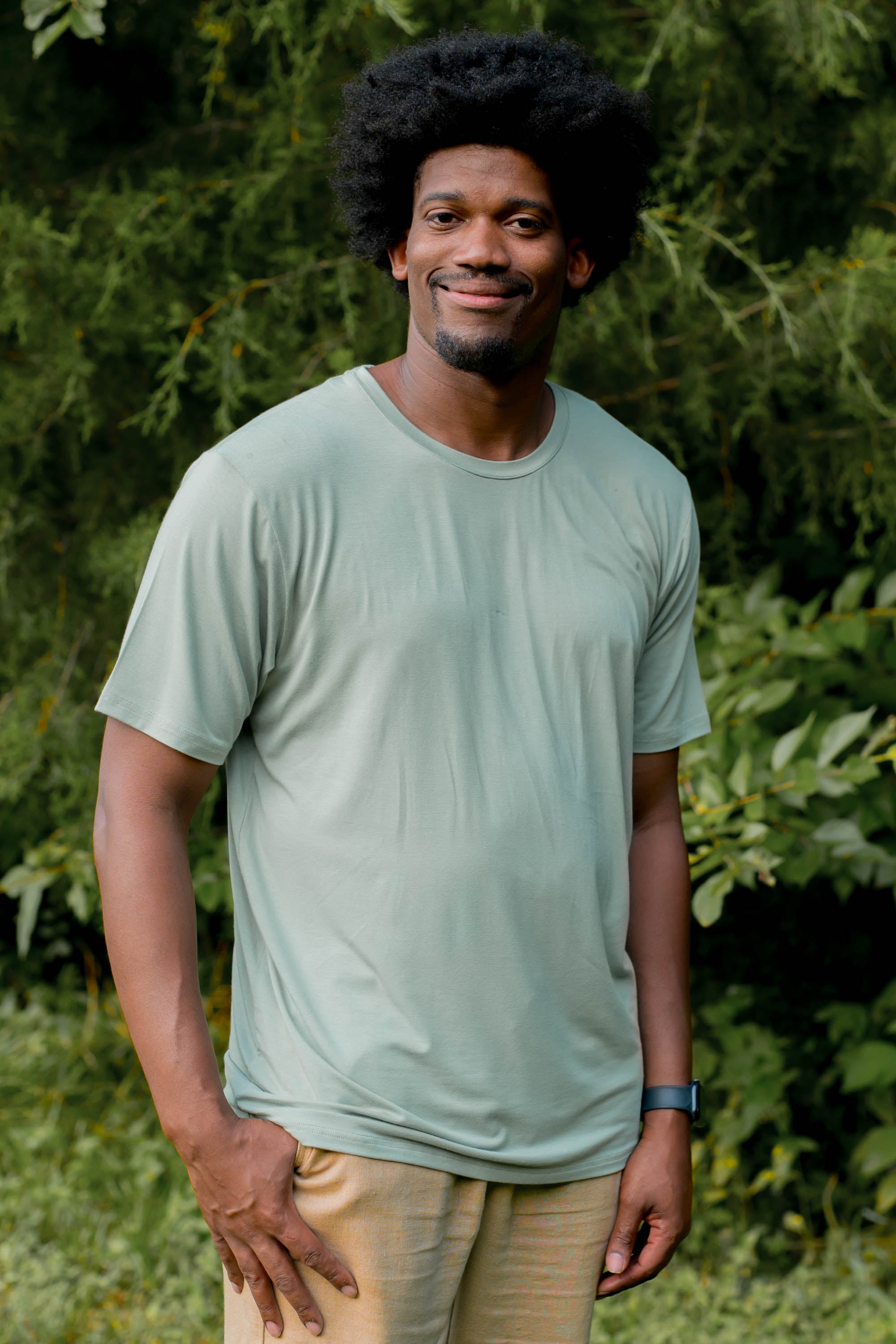 Smiling model wearing the Men's Crew Neck Tee in Thyme