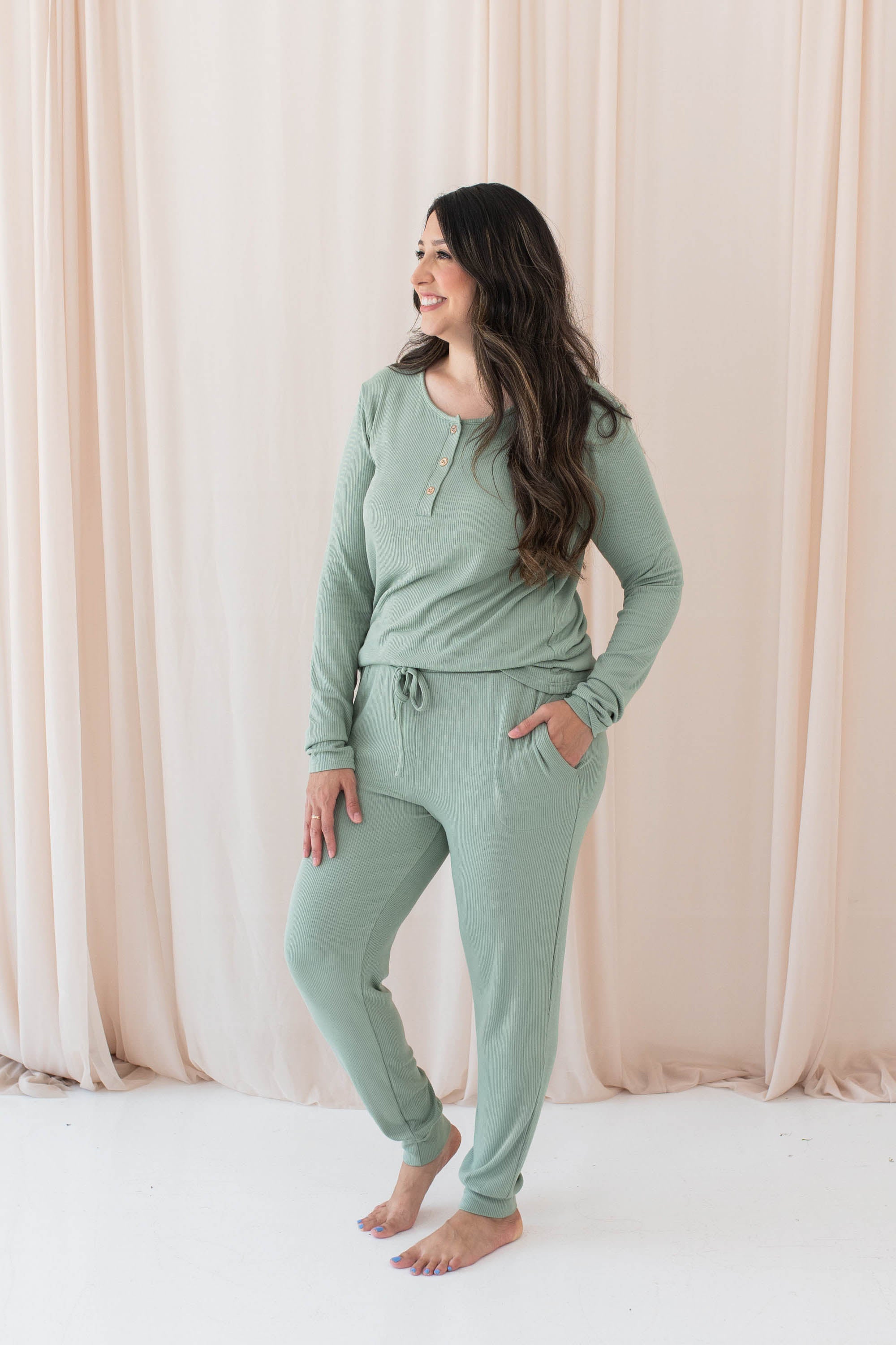 Model wearing the Women's Ribbed Jogger Pant in Thyme with one hand in pants pocket
