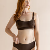 Woman modeling the Women's Pumping Bra in Toffee paired with matching underwear in front of a beige back ground 

