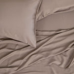 Close up of the Bamboo Sateen Pillowcase Set in Truffle with matching bed sheets on a bed