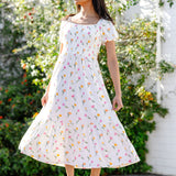 Female model turning wearing the Women’s Smocked Dress in Tulip showing the twirl in the skirt of the dress