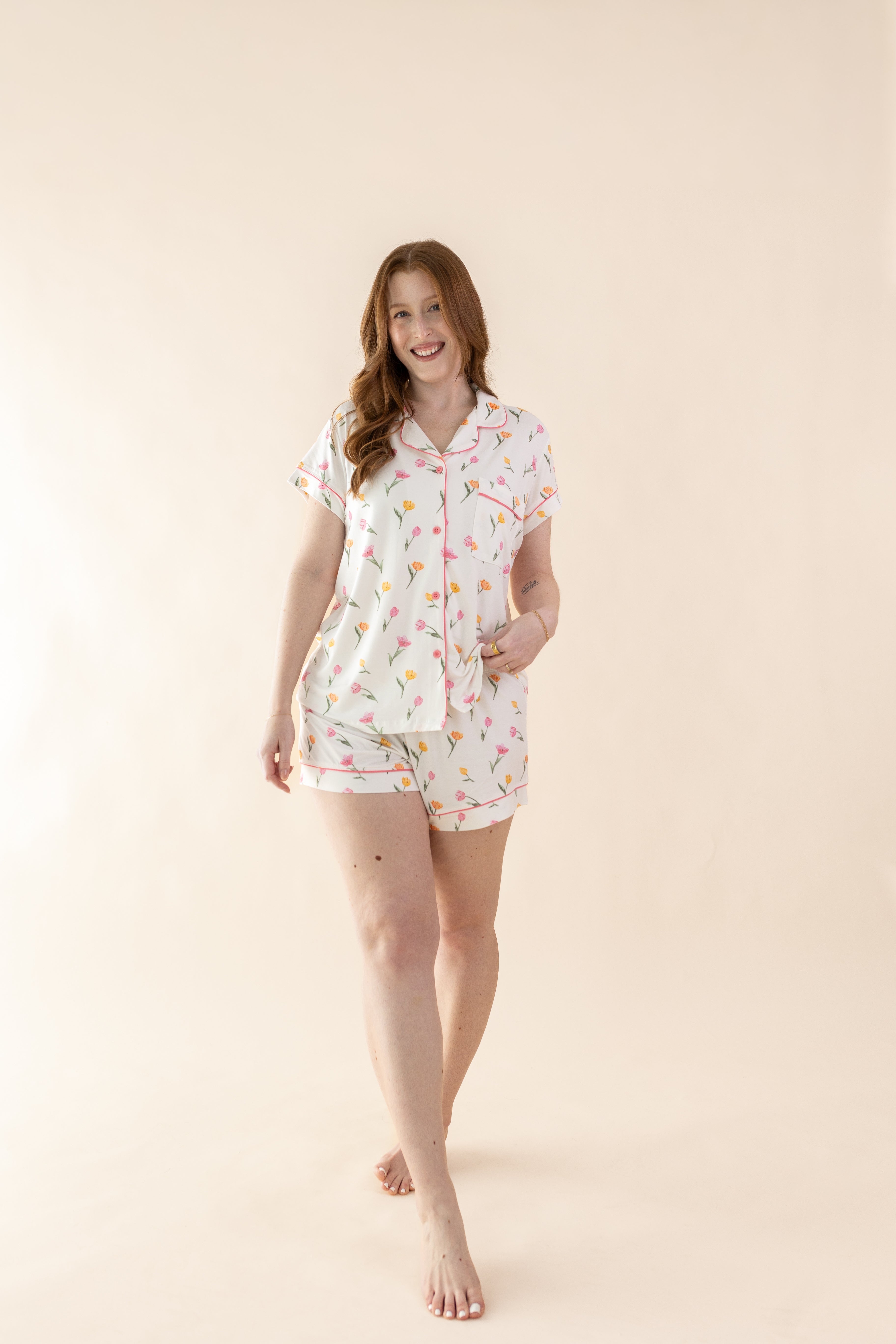 Female model walking wearing the Women's Short Sleeve Pajama Set in Tulip in front of a light cream background
