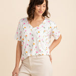 Female model wearing the Women's Relaxed Fit V-Neck in Tulip paired with light beige pants