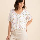Female model wearing the Women's Relaxed Fit V-Neck in Tulip paired with light beige pants