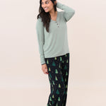 Model looking to the side with one hand on her head and wearing the Kyte Women's Lounge Pants in Twinkle Tree