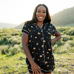 Woman modeling Women's Short Sleeve Pajama Set in Under the Stars with hand on hip in Yellowstone National Park